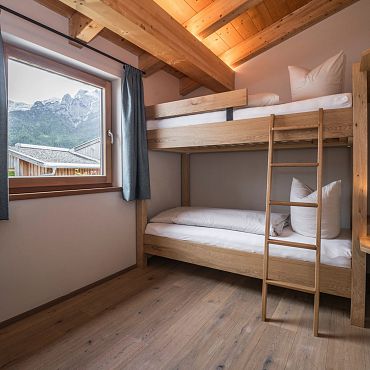 Ein Zimmer mit Stockbett und Holzeinrichtung, ideal für Kinder