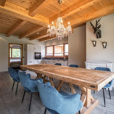 Ein stilvoller Essbereich in den Alpegg Chalets mit Holztisch und Kronleuchter
