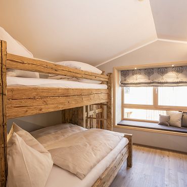 Alpegg Chalets in Waidring bei Kitzbühel_uriges Schlafzimmer mit Altholz